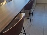 a long table with chairs and a vase of flowers on it