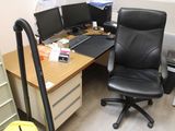a black office chair sitting in front of a computer desk