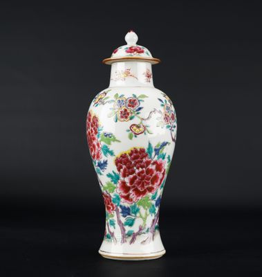 a white and red vase with flowers on it on a black surface