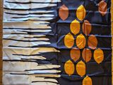 a flag made out of oranges and knives on a wooden floor