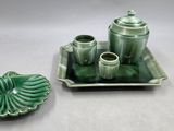 un plateau vert sur lequel se trouvent un service à thé et une tasse