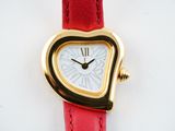 a heart shaped watch on a red strap on a white surface