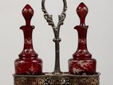 two red vases sitting on a stand on a table