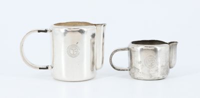 an image of a silver pitcher and a silver cup on a white surface
