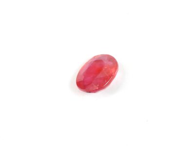 une pierre ovale rouge sur une surface blanche
