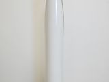 a white vase sitting on the floor in front of a white wall