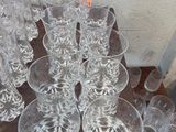 a lot of glasses sitting on a table in front of a wall