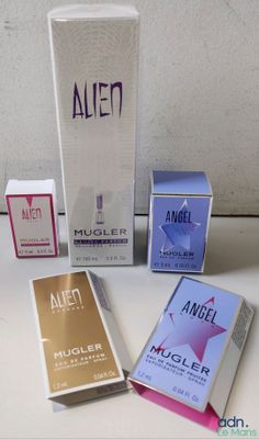 trois boîtes d'eau de Cologne et une boîte d'eau de Cologne posées sur une table