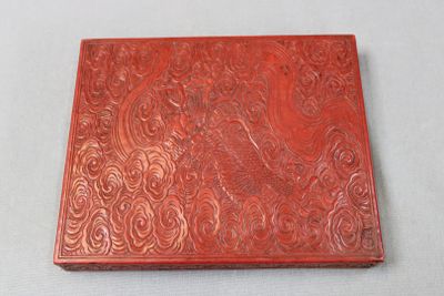 une vieille boîte rouge ornée de motifs complexes sur un fond blanc