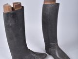 une paire de bottes en cuir noir avec des talonnettes en bois, sur fond blanc