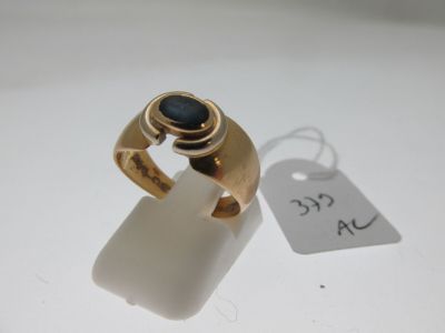 an image of a gold ring with a blue stone on it