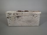 a white box with a handle on a gray surface