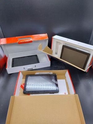 trois boîtes contenant des appareils électroniques, posées sur une table