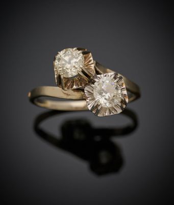 un gros plan de deux bagues en diamant posées sur une surface noire