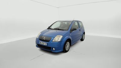 La petite voiture bleue est garée dans une pièce blanche.
