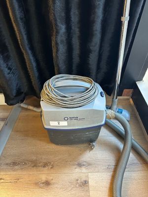 a vacuum that is sitting on the floor next to a window
