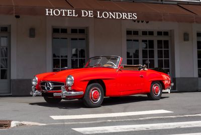 a red car that is parked in front of a hotel