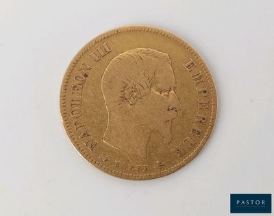 gros plan d'une pièce d'or sur une surface blanche