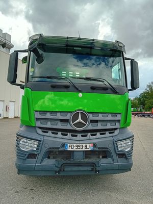 un grand camion vert garé sur un parking
