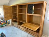 une grande bibliothèque en bois avec des tiroirs dans une pièce