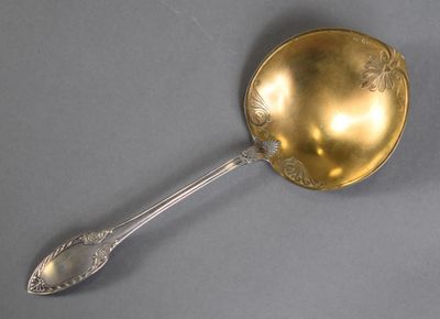 a gold spoon with a spoon handle on a gray surface