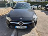 a black mercedes cla parked in a parking lot next to a fence