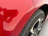 a close up of a red car ' s tire on the street