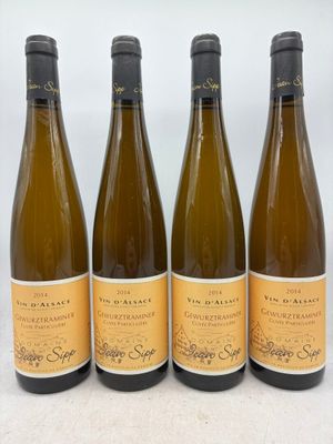 quatre bouteilles de vin sont alignées sur une table