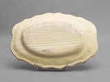 an image of a white plate on a stand on a gray surface