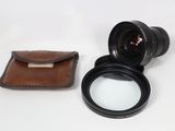 a camera lens sitting next to a wallet on a table