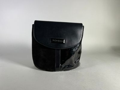 black leather purse on a white surface with a white background