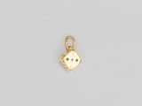 un petit pendentif en forme de dé doré sur fond blanc