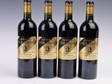 four bottles of wine are lined up on a white surface