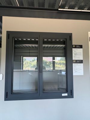 une photo d'une fenêtre noire sur un mur blanc