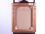 an old picture frame sitting on top of a wooden easel