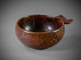 an old wooden bowl sitting on top of a table with writing on it
