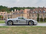a silver sports car parked in front of a large building