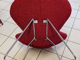 a red chair that is sitting on a tile floor