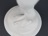 a white statue of a hand on top of a coin