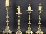 un ensemble de quatre bougeoirs en laiton ancien