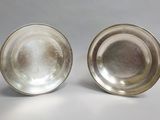pair of silverplated bowls on a white background