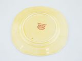 a close up of a yellow plate on a white surface