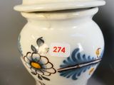 un vase blanc orné de fleurs bleues et jaunes
