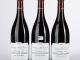 trois bouteilles de vin sont alignées sur une surface blanche