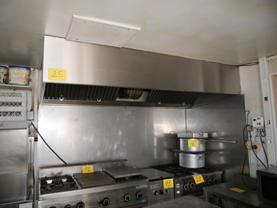 une grande cuisine en inox équipée d'une cuisinière et d'un four