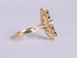 a close up of a gold ring with a red and white diamond center