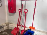 two red shovels and a green bucket in a room