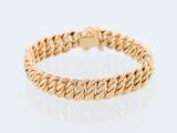 a gold bracelet on a white background