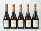 six bouteilles de vin sont alignées sur une surface blanche