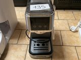 une cafetière posée sur le carrelage d'une cuisine